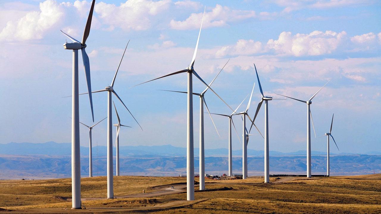 Wind turbines generating clean power in the plains with a blue sky backdrop